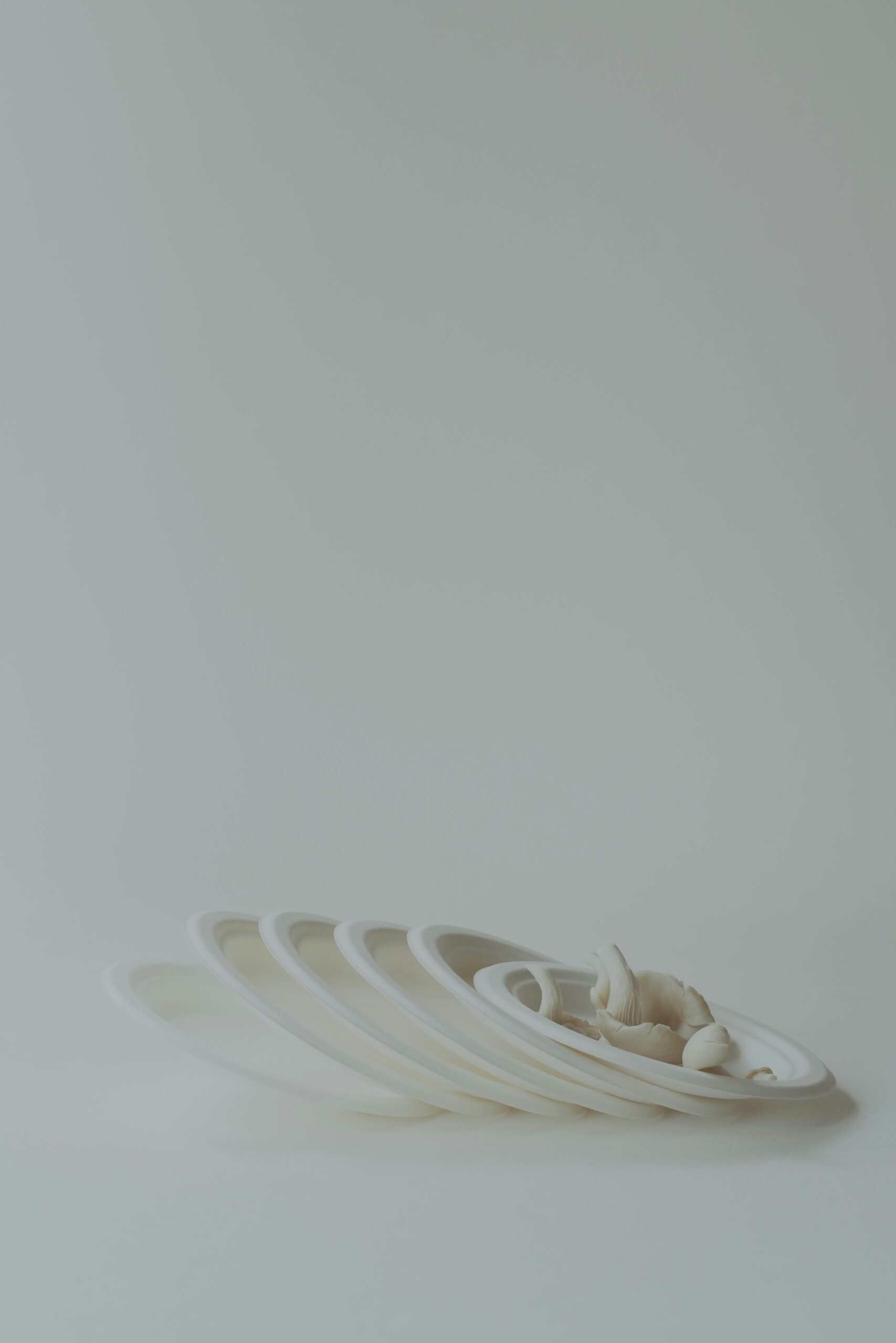 A stack of white plates sitting on top of a white table